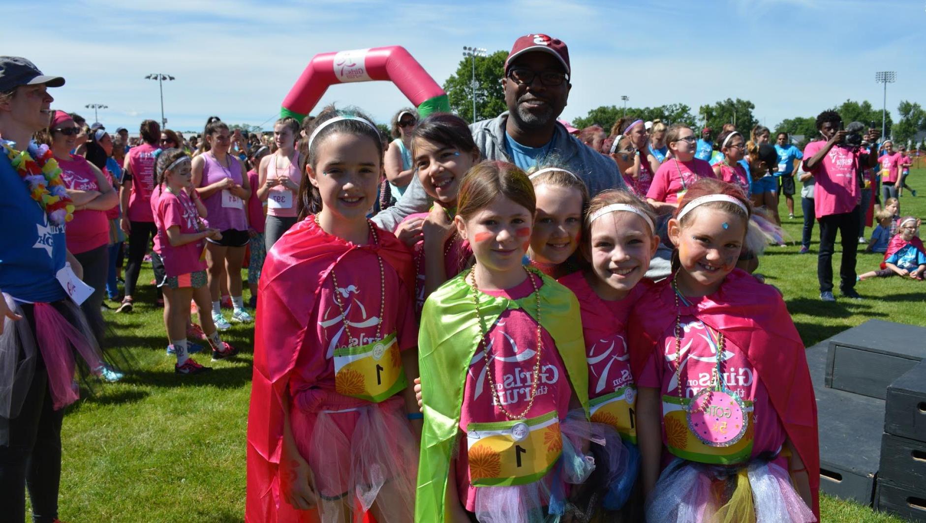 Calvin Hill poses with Girls on the Run participants. 