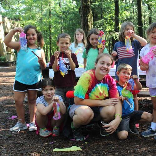 Group of campers hold up their craft project