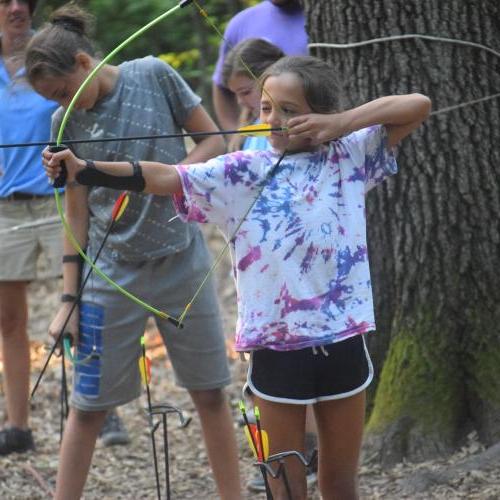 A girl shoots a bow and arrow